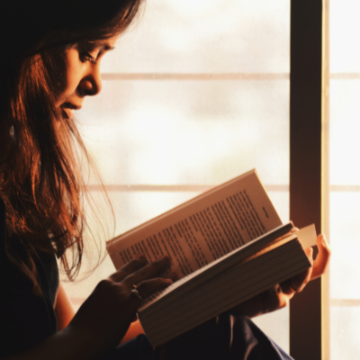 Una chica leyendo un libro a contraluz